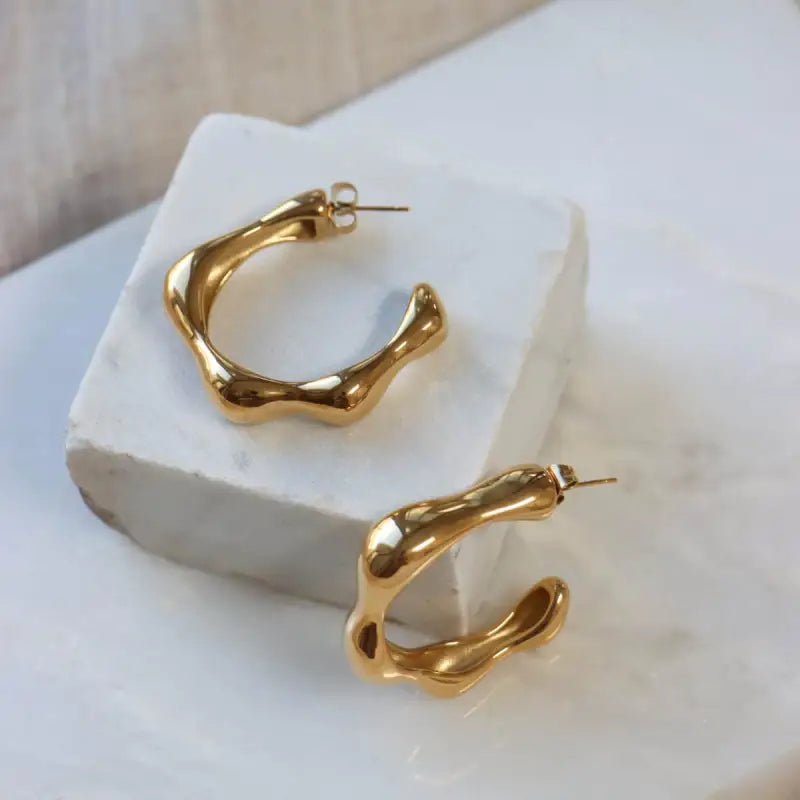 Gouden abstracte hoopoorbellen Label Kiki Big Wavy opvallende oorbellen